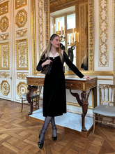 a lady wears a black velvet  midi dress